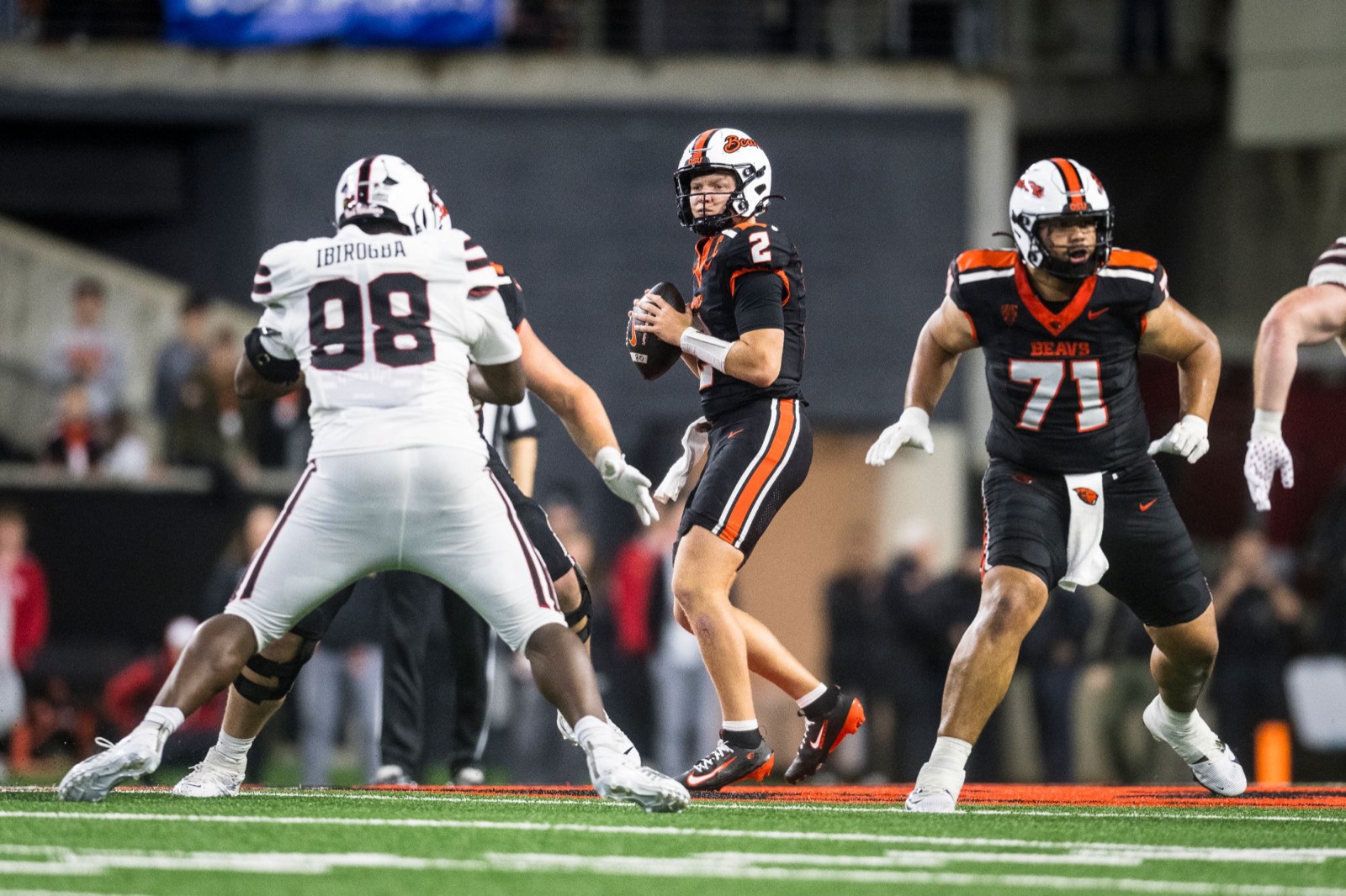 Braden Atkinson dropping back to pass in Oregon State&rsquo;s black uniform as a defender closes in