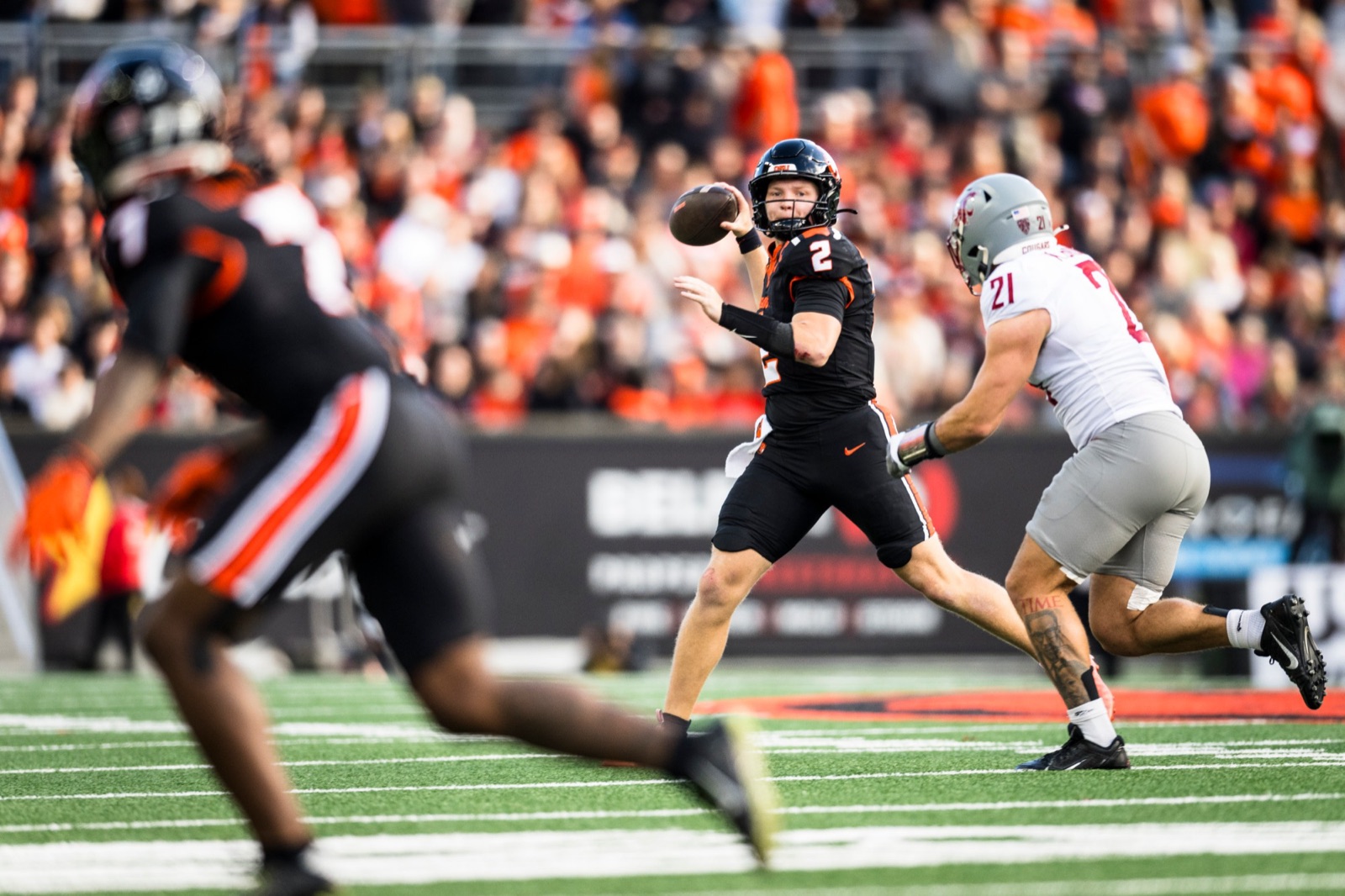 Braden Atkinson rolling out to throw with a Washington State defender in pursuit