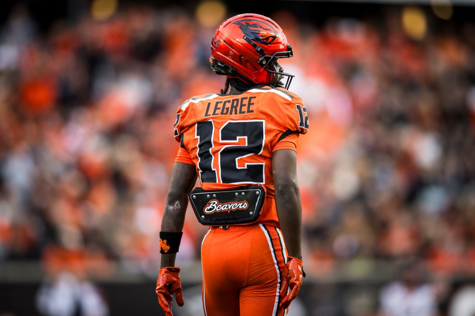 Jesse Legree, number 12, seen from behind in an orange Oregon State uniform in front of the Reser Stadium crowd